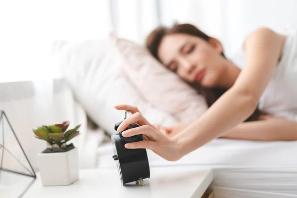 Mulher dormindo e despertador no quarto em casa — Fotografia de Stock