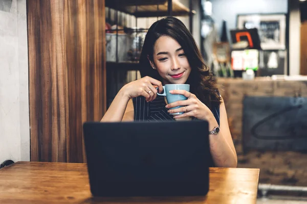İş kadını oturma ve dizüstü bilgisayar ve içki ile çalışıyor — Stok fotoğraf