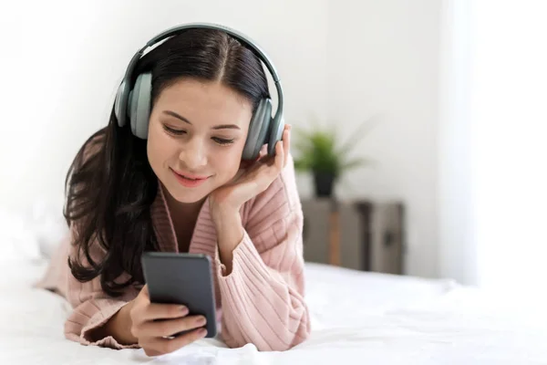 Hermosa joven mujer relajante escuchando música con auriculares —  Fotos de Stock