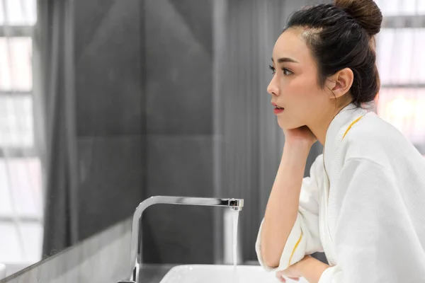 美しい若いアジアの女性は、水とsmできれいな顔を洗います — ストック写真