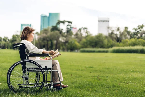 Kıdemli yetişkin yaşlı asya kadınlar tekerlekli sandalye ve okuma bo oturup — Stok fotoğraf