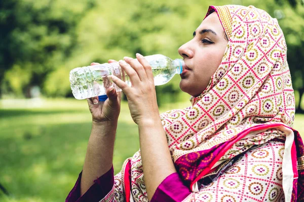 Портрет счастливой арабской мусульманки, пьющей хиджабское платье — стоковое фото