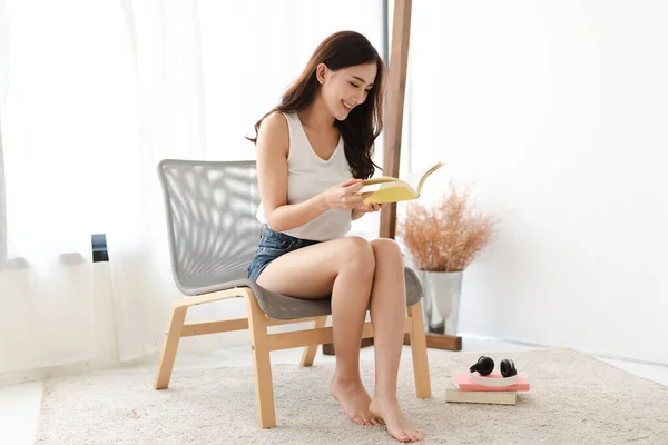 Jonge vrouw ontspannend lezen boek thuis — Stockfoto