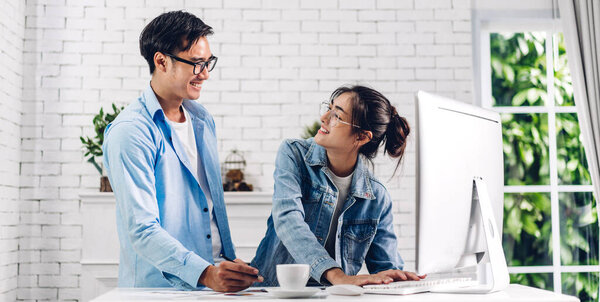 Young asian couple relaxing using desktop computer working and video conference meeting online chat.Creative business couple planning and brainstorm at home.work from home concept