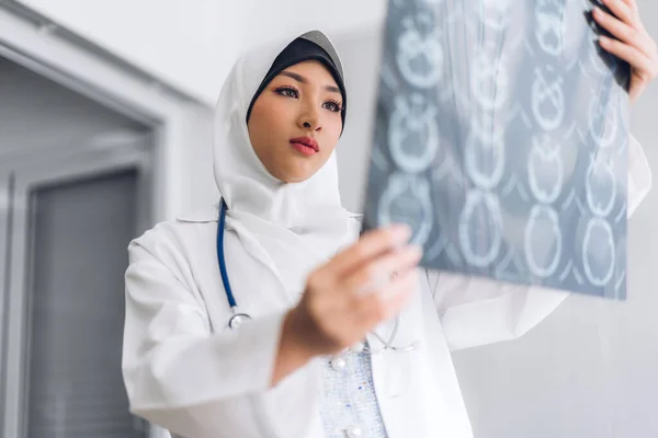 Muslim asian woman doctor looking at x-ray photo.healthcare and medicine