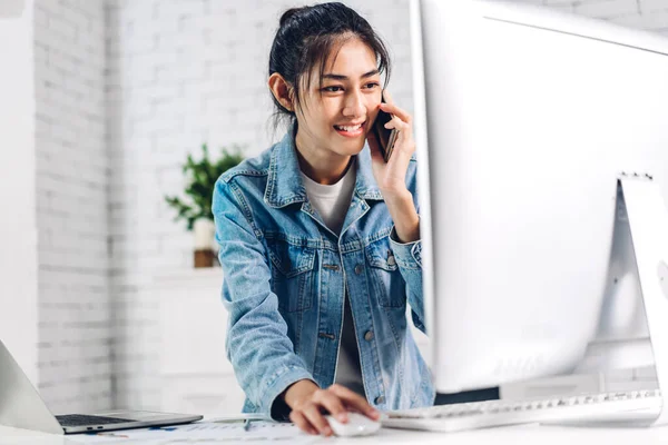 Young smiling happy asian woman relaxing using desktop computer working and video conference meeting online chat at home.work from home concept