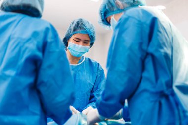 Profesyonel anestezi uzmanı doktor tıp ekibi ve asistanı modern hastane acil servisinde cerrahi ekipmanla jinekolojik ameliyata hazırlanıyor.