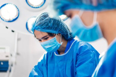 Profesyonel anestezi uzmanı doktor tıp ekibi ve asistanı modern hastane acil servisinde cerrahi ekipmanla jinekolojik ameliyata hazırlanıyor.