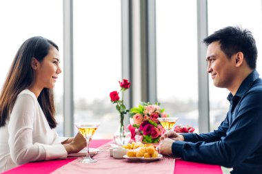 Romantik, genç ve mutlu çift rahatça konuşuyor ve şarap içiyor. Restoranda kutlama yapıyorlar.