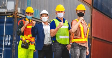Korunaklı maske takarak koronavirüs için ayakta ve karantinada olan grup kargo ustabaşısı.