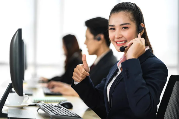 在呼叫中心的台式机上与耳机一起工作和交谈的亚洲人快乐的亚洲人微笑呼叫中心商业运营商客户支持团队电话服务 — 图库照片