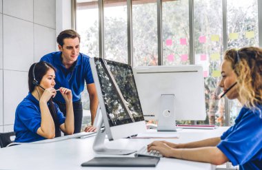 Mutlu çağrı merkezi gülümseme operatörü müşteri destek ekibi telefon hizmeti ajansı çağrı merkezindeki masaüstü bilgisayarında çalışıyor ve kulaklıkla konuşuyor