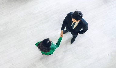 Top view Image zarif takım elbiseli iki iş ortağı modern ofiste birlikte başarılı bir tokalaşma. Ortaklık onayı ve teşekkür jest konsepti.