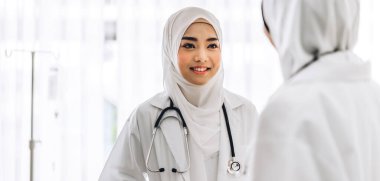 İki Müslüman Asyalı kadın doktor hastanede çalışıyor ve konuşuyor. Sağlık ve tıp.