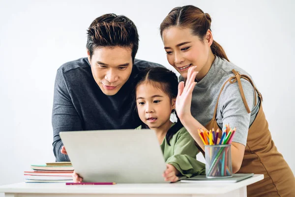 Portrait enjoy happy smiling love asian family father and mother with little asian girl learning and looking at laptop computer studying with online education e-learning system with teacher tutor at home