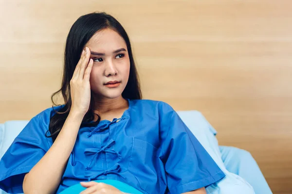 Portrait of smiling asian woman patient sitting on bed looking at camera with health medical care express trust and Insurance concept in room at hospital