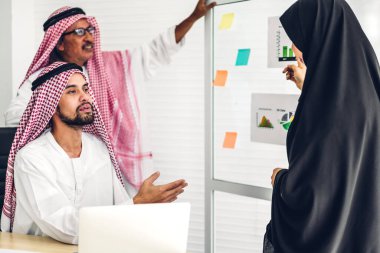 Üniversiteli Arap iş adamlarının dizüstü bilgisayar ve belge raporlarıyla çalışmalarının başarısı. Yaratıcı Arap iş adamları yeni bir başlangıç projesi projesiyle buluşup strateji analizi planlıyorlar.