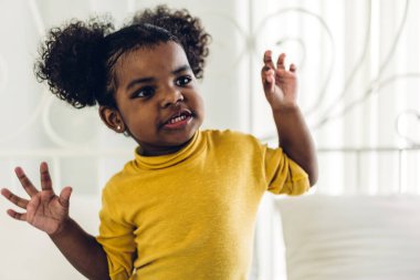 Mutlu gülümseyen küçük bir çocuğun portresi. Afro-Amerikan kızı evde.