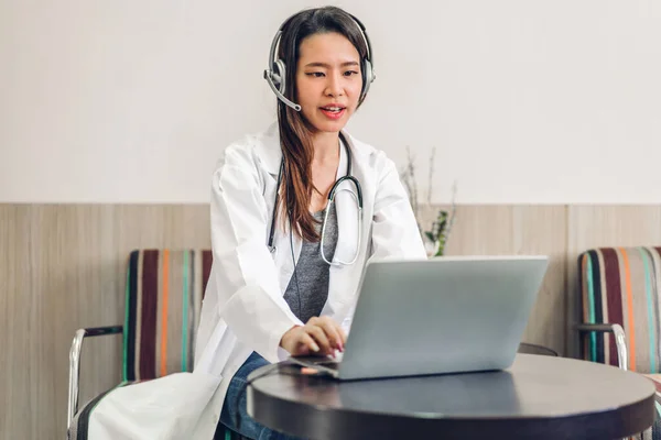 Young asian doctor woman using laptop computer working and video conference meeting.Young doctor talk with headset at hospital