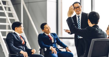 Danışma toplantısı konferans seminerinde bir grup insanın önünde duran ve salon veya seminer odasında soruları cevaplamak için elini gösteren bir işadamı. Sunum ve koçluk kavramı