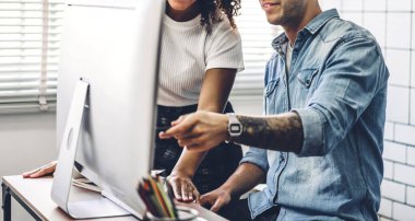 Masaüstü bilgisayarı ile çalışan ve stratejiyi tartışan iki iş adamı. Modern çalışma tavan arasında planlama ve beyin fırtınası yapan yaratıcı iş adamları. Takım çalışması kavramı.