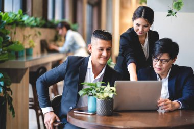 Proje ile fikirleri paylaşmayı tartışan bir grup profesyonel iş adamı. Yeşil santral terasında dizüstü bilgisayarla çalışan yaratıcı iş adamları modern çalışma odalarını dekore ettiler.