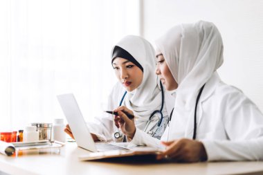 Hastanede tablet bilgisayarla çalışan iki Asyalı kadın doktor. Sağlık ve tıp.