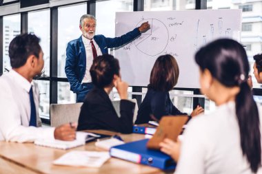 Profesyonel iş toplantıları ve yeni başlangıç projesiyle strateji tartışmaları. Yaratıcı iş adamları modern çalışma ortamında belge raporlarıyla plan yapıyor ve beyin fırtınası yapıyorlar. Takım çalışması kavramı.