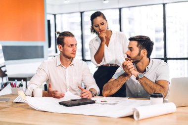 Profesyonel iş toplantıları ve yeni başlangıç projesiyle strateji tartışmaları. Yaratıcı iş adamları modern çalışma ortamında belge raporlarıyla plan yapıyor ve beyin fırtınası yapıyorlar. Takım çalışması kavramı.