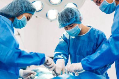 Profesyonel anestezi uzmanı doktor tıp ekibi ve asistanı modern hastane acil servisinde cerrahi ekipmanla jinekolojik ameliyata hazırlanıyor.