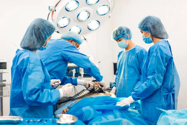 専門麻酔科医師チームと現代病院手術緊急治療室で手術機器を使用して手術を行う婦人科手術の患者を準備アシスタント — ストック写真