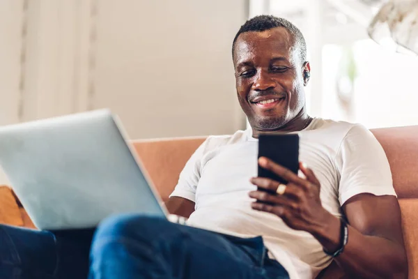 Young black african man relaxing using laptop computer working and video conference meeting at home.Young creative african man talk with headset.work from home concept