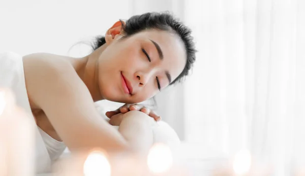 Smiling of young beautiful pretty asian woman clean fresh healthy white skin spa treatment relaxing lying on towel in massaging and spa salon