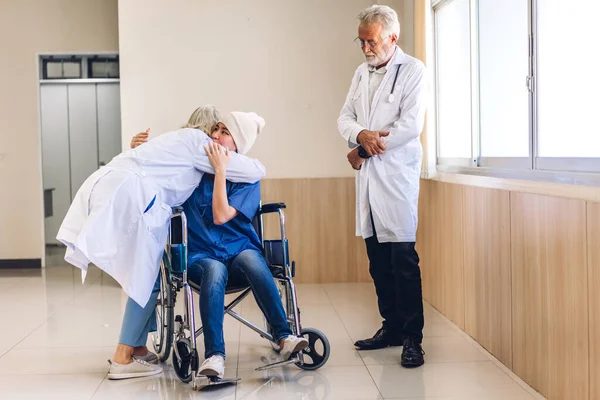 Professional medical doctor team with stethoscope in uniform discussing and hug with patient woman with cancer cover head with headscarf of chemotherapy cancer in hospital.health care concept