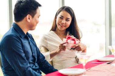 Genç yakışıklı bir adam kız arkadaşına hediye kutusu sürprizi veriyor.