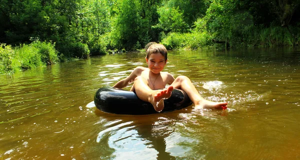 소년은 강에서 튜브에 재미를 가지고 — 스톡 사진