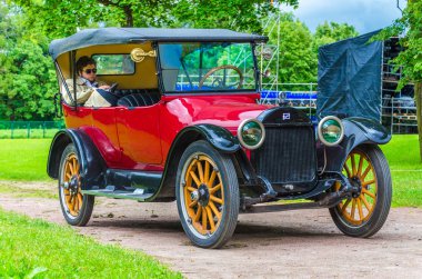 Gatchina, Leningrad region, Rusya - 03 Ağustos 2019:siyah sakallı siyah gözlüklü bir adam retro bir arabanın arka koltuğunda kitap okuyor