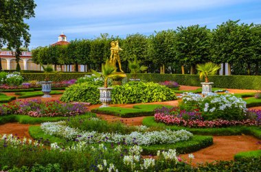 Monplaisir Sarayı, 18. yüzyılda yapılmış, Peterhof 'un kırmızı çatısı yeşil ağaçlar, çalılar ve mavi gökyüzüne karşı çiçeklerle çevrili..