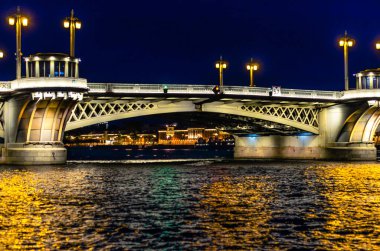 Neva Nehri 'ni kaplayan bir köprü. Saint Petersburg' da beyaz bir gecede fenerlerle ve projektörlerle aydınlatılmış.