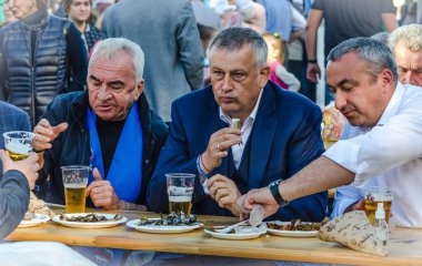 Novaya Ladoga, Leningrad bölgesi, Rusya - 29 Ağustos 2020: Leningrad bölgesi valisi Alexander Beglov meslektaşları ve yürüyen insanlar füme ve kurutulmuş eritilmiş eritilmiş yiyecekler yiyor. 