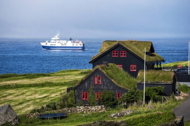 Tipik Faroe ahşap evler Kirkjubour Köyü ve arka plan, Faroe dili Streymoy Adası feribot botu geçen ile Skopunarfjordur suları 