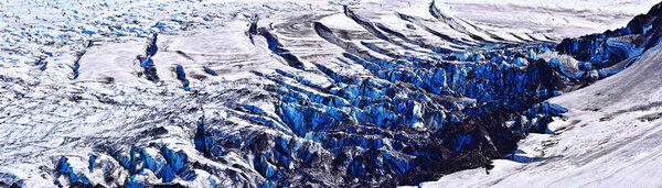 Panoramic view at the glassier fracture, Cracked glacier surface with deposits of black volcanic cinder, Kverkfjoll massif in Icelandic Vatnajokull National Park in Icelandic Vatnajokull National Park