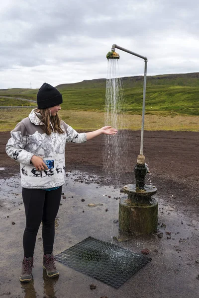 女の子 Krafla 火山島北部地区に取り付けられているシャワーの暖かい水をテスト — ストック写真