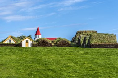 Çim evler Kuzey İzlanda'daki Glaumbaer oluşan geleneksel İzlanda çiftlikte güney kapısından görüldüğü gibi ahşap kilisenin tepesine gerisindedir. 