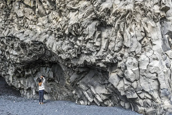 Menina adolescente está tirando fotos de falésias de Basalto no fundo do — Fotografia de Stock