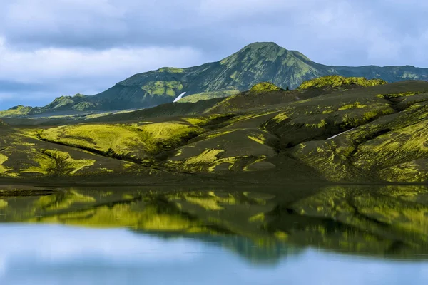 As formações de lava cobertas com musgo islandês amarelo-verde refletem — Fotografia de Stock