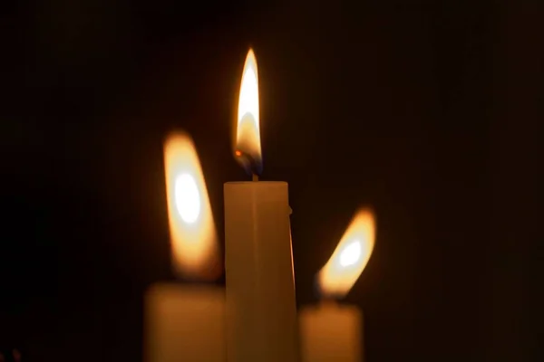 Tři plameny svíčky s tmavým pozadím — Stock fotografie