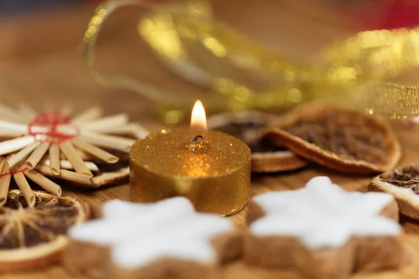 Gouden kaars met kerstkoekjes en decoratie — Stockfoto