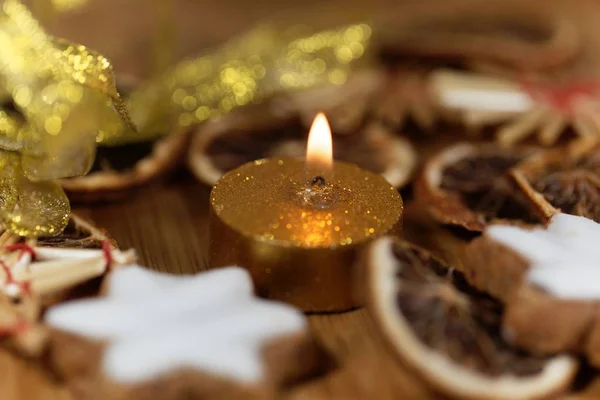 Gouden kaars met kerstkoekjes en decoratie — Stockfoto