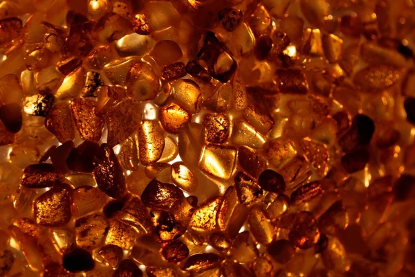 Amber grains with backlight illumination — Stock Photo, Image